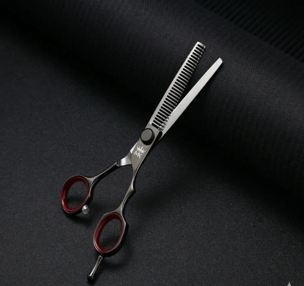 Professional hair thinning scissors with red finger rings on black textured background