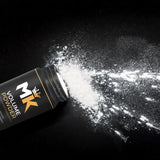 Hair volume powder bottle spilling white powder on black background, hair styling product