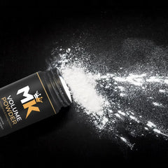 Hair volume powder bottle spilling white powder on black background, hair styling product